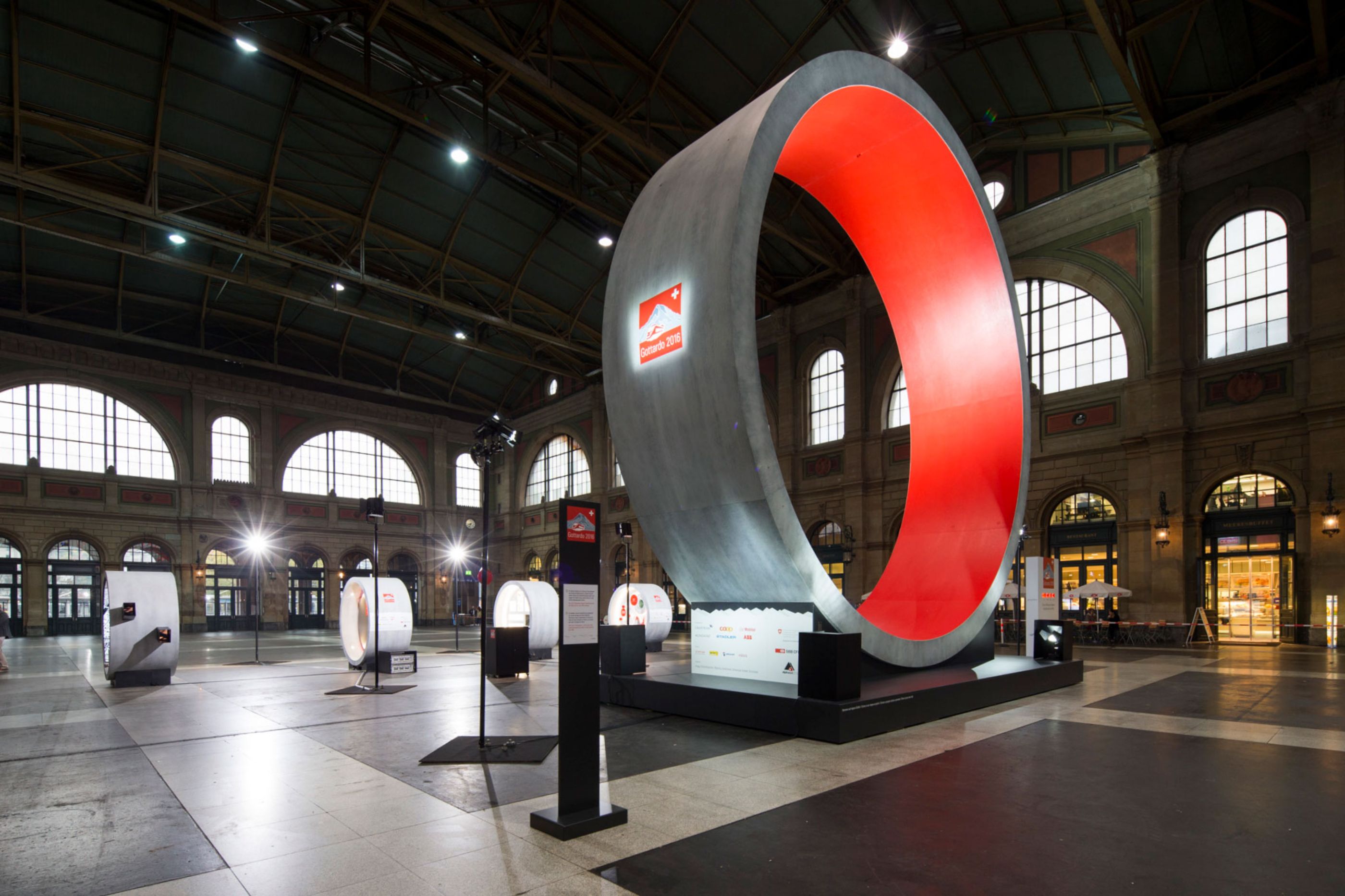 The Gottardo 2016 installation in Zurich Hauptbahnhof — the large illuminated red ring as the centrepiece, with the row of tunnel modules alongside