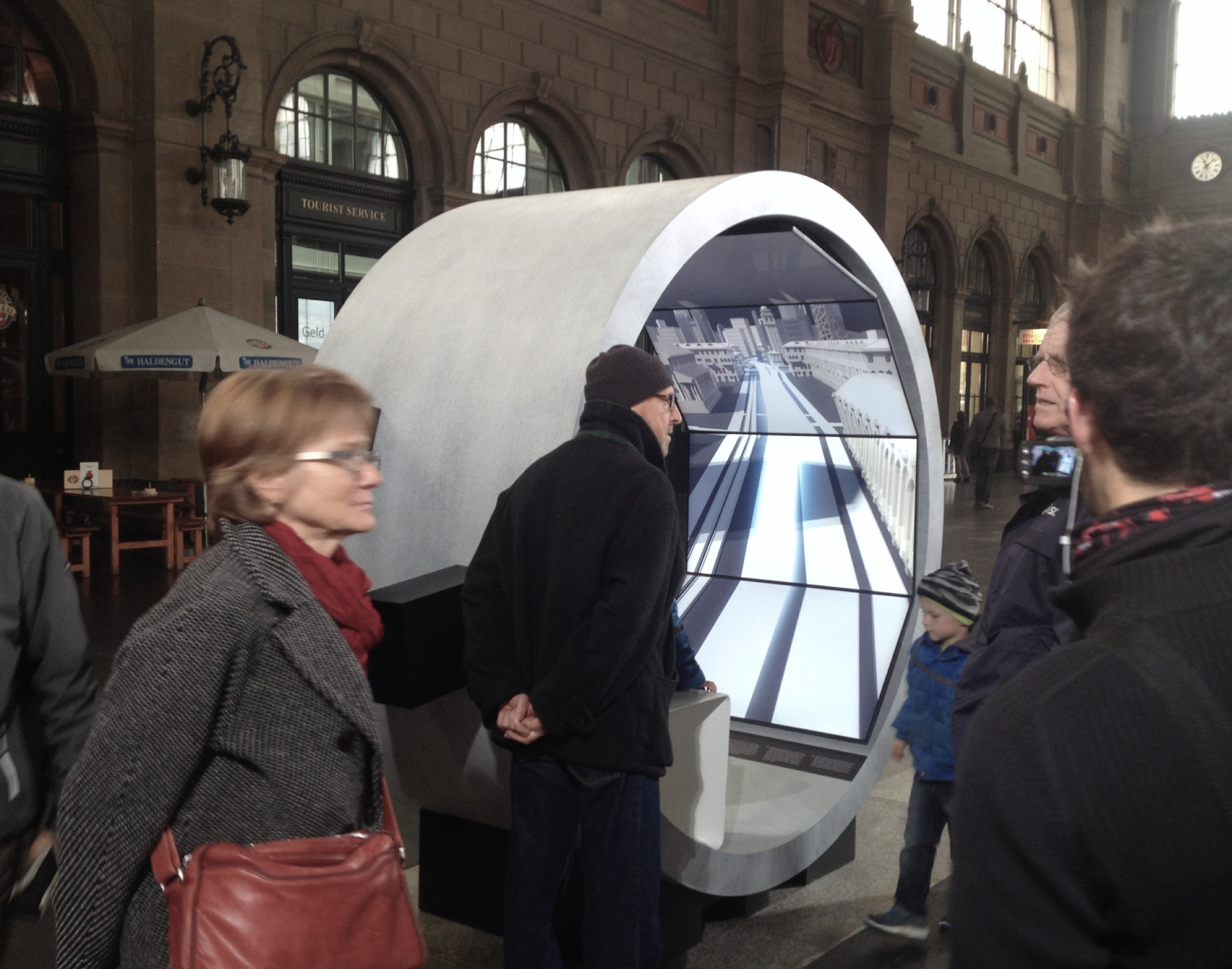 A visitor watching the monochrome cityscape motion film on the screen set inside a Gottardo 2016 tunnel module